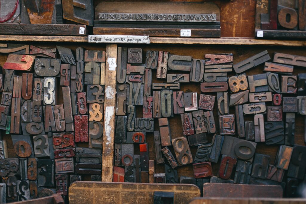 Wooden letters used for printing are shown face up and ink stained in a drawer.