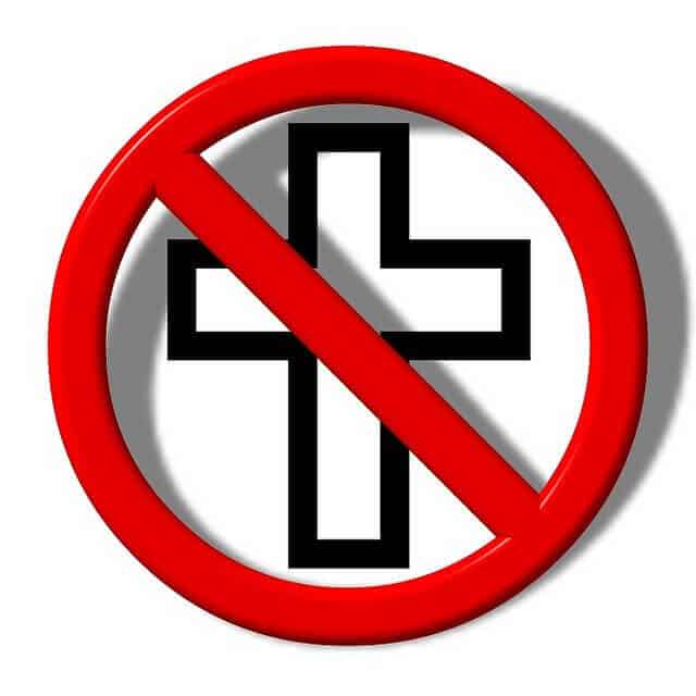 A white cross is in a red circle with a red diagonal line over it.