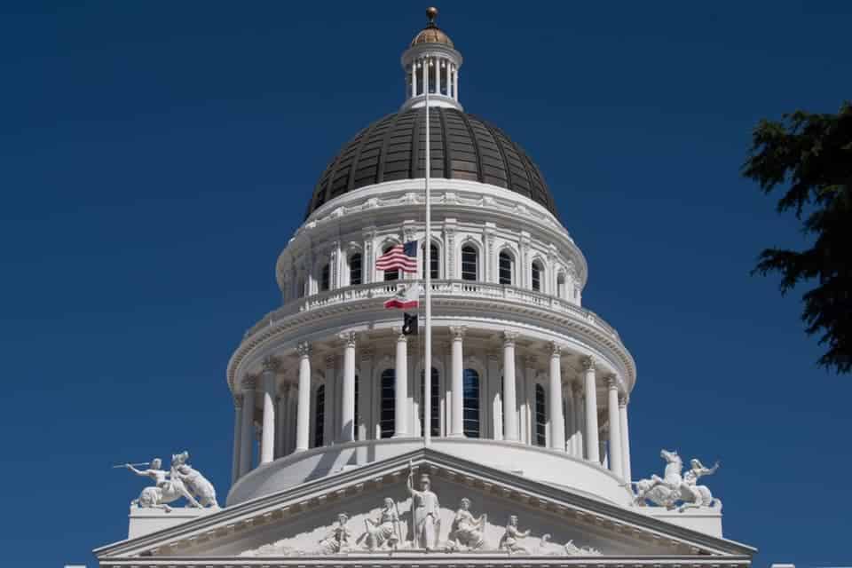 A US flag at half mast over the CA capitol in Sacramento.