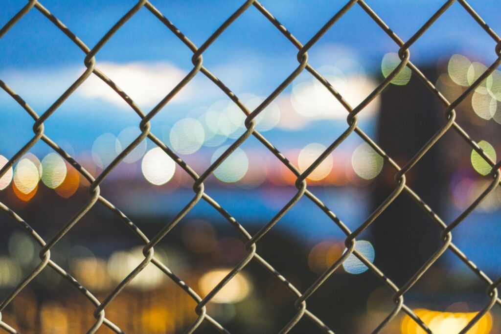 A chain link fence with a blurred background.