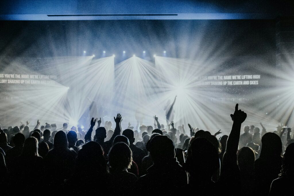 Church worship service with a lot of people and huge screens with lyrics.